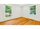 Bright bedroom featuring hardwood floors and two windows with natural light at 508 Bolin Creek Dr, Carrboro, NC 27510