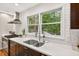 Updated kitchen features stainless steel appliances, white subway tile, and double-basin sink with wooded view at 508 Bolin Creek Dr, Carrboro, NC 27510