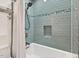 Shower-tub combination featuring bright turquoise subway tile and a sleek shower head at 508 Bolin Creek Dr, Carrboro, NC 27510