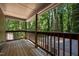 Covered back porch overlooking lush green trees with rustic wooden railing at 5257 Vann St, Raleigh, NC 27606