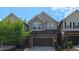 Two-story townhome exhibits a well-kept exterior, a dark colored garage door, and a blue sky above at 536 Rockcastle Dr, Cary, NC 27519