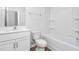 Bright, all-white bathroom featuring a shower-tub combo and a sleek vanity at 5556 Henley Ridge Dr, Graham, NC 27253