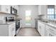 Modern kitchen with stainless steel appliances, white cabinets and granite countertops at 5556 Henley Ridge Dr, Graham, NC 27253