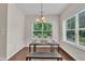 Cozy dining area with modern table, bench, window view, hardwood floors, and pendant lighting above at 601 Minerva Dale Dr, Fuquay Varina, NC 27526