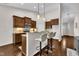 Open kitchen design with stainless appliances, breakfast bar, granite counters, dark wood cabinets, and pendant lighting at 601 Minerva Dale Dr, Fuquay Varina, NC 27526