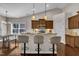 Bright kitchen featuring a breakfast bar with pendant lights, granite countertops, stainless appliances and dark wood cabinetry at 601 Minerva Dale Dr, Fuquay Varina, NC 27526