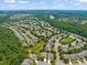 An aerial view of a neighborhood filled with homes surrounded by lush trees with a pond and lake in the distance at 606 Corrigan Way, Cary, NC 27519