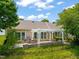 An inviting back patio with an outdoor kitchen and pergola covering, nestled among lush landscaping and a black metal fence at 606 Corrigan Way, Cary, NC 27519