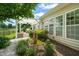 Backyard featuring a stone fountain, pergola-covered outdoor kitchen, and well-manicured landscaping at 606 Corrigan Way, Cary, NC 27519