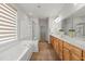 Bright bathroom featuring a soaking tub, glass shower, and double vanity at 606 Corrigan Way, Cary, NC 27519