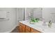 A bathroom with double vanity sinks, wood cabinets, and modern fixtures at 606 Corrigan Way, Cary, NC 27519