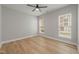 A bright bedroom featuring hardwood floors, neutral paint, and two large windows with natural light at 606 Corrigan Way, Cary, NC 27519