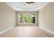 Bright bedroom with large windows, tray ceiling with ceiling fan, and light hardwood floors at 606 Corrigan Way, Cary, NC 27519