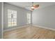 Cozy bedroom featuring hardwood floors, ceiling fan, and windows for natural light at 606 Corrigan Way, Cary, NC 27519