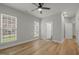 A well-lit bedroom featuring hardwood floors and ample natural light from two large windows at 606 Corrigan Way, Cary, NC 27519