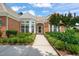 Charming brick home featuring a neatly landscaped front entrance with a walkway leading to an arched doorway at 606 Corrigan Way, Cary, NC 27519