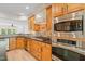 Kitchen featuring wood cabinets, granite countertops, and stainless steel appliances at 606 Corrigan Way, Cary, NC 27519