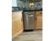 Close-up of kitchen dishwasher with wood cabinets and dark countertops at 606 Corrigan Way, Cary, NC 27519
