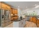 Kitchen featuring wood cabinets, granite countertops, stainless steel appliances, and an island at 606 Corrigan Way, Cary, NC 27519