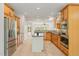 Spacious kitchen with stainless steel appliances, center island, and light wood flooring at 606 Corrigan Way, Cary, NC 27519