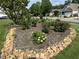 Beautiful rose garden with colorful flowers and stone edging, enhancing the property's curb appeal at 606 Corrigan Way, Cary, NC 27519