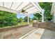 A covered outdoor kitchen featuring stone counters, a grill, and a beautiful backyard view at 606 Corrigan Way, Cary, NC 27519