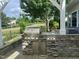 Close up of built-in grill in the outdoor kitchen, with view of back yard at 606 Corrigan Way, Cary, NC 27519
