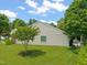 A well-maintained side yard with green grass and landscaping surrounding the house featuring neutral-colored siding at 606 Corrigan Way, Cary, NC 27519