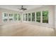 A sunroom features hardwood floors, recessed lighting, and many windows overlooking trees at 606 Corrigan Way, Cary, NC 27519