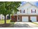 Charming townhome with a brick facade, a two-car garage, and a well-maintained front yard at 617 Woodson Dr, Clayton, NC 27527