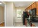 Compact kitchen with black appliances, wood cabinets, and a window offering natural light and a pantry nearby at 617 Woodson Dr, Clayton, NC 27527