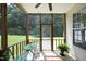 View of the screened porch featuring green chairs, a table and greenery at 617 Woodson Dr, Clayton, NC 27527