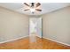 Spacious bedroom with hardwood floors, ceiling fan, and open door to hall at 6201 King Croydon Ct Ct, Raleigh, NC 27603
