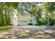 Charming yellow house with a two-car garage and driveway surrounded by mature trees at 6201 King Croydon Ct Ct, Raleigh, NC 27603