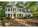Charming yellow two-story home with black shutters surrounded by lush greenery and mature trees at 6201 King Croydon Ct Ct, Raleigh, NC 27603
