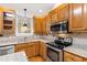 Well-equipped kitchen with granite countertops, stainless steel appliances, and wooden cabinetry at 6201 King Croydon Ct Ct, Raleigh, NC 27603
