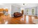 Spacious living room with hardwood floors, a leather couch, and an open view into the kitchen at 6201 King Croydon Ct Ct, Raleigh, NC 27603