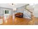 Open-concept living room with hardwood floors, leather furniture, and a staircase at 6201 King Croydon Ct Ct, Raleigh, NC 27603