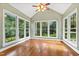 Bright sunroom featuring hardwood floors, large windows, and a vaulted ceiling with a ceiling fan at 6201 King Croydon Ct Ct, Raleigh, NC 27603