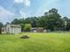 Spacious, green backyard featuring storage sheds, a firepit, and a trampoline at 635 Raymond Dr, Wendell, NC 27591
