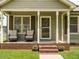 Inviting front porch with brick trim, rocking chairs and decorative plants at 635 Raymond Dr, Wendell, NC 27591