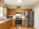 Well-lit kitchen featuring modern stainless steel appliances and oak cabinets at 635 Raymond Dr, Wendell, NC 27591