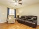 Bright living room with hardwood floors, ceiling fan, and comfortable leather sofa at 635 Raymond Dr, Wendell, NC 27591