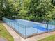 Outdoor blue basketball court with green trees surrounding the fenced perimeter at 6422 English Oaks Dr, Raleigh, NC 27615