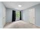Bright bedroom featuring blue walls, neutral carpet, and natural light from a window at 6422 English Oaks Dr, Raleigh, NC 27615