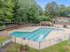 Fenced community pool surrounded by trees and lounge chairs at 6422 English Oaks Dr, Raleigh, NC 27615