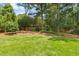 Expansive backyard with mature trees, a lush green lawn, and mulch beds, offering a private outdoor space at 6608 Quiet Cove Ct, Raleigh, NC 27612