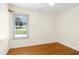 A bright bedroom features a large window providing plenty of natural light and hardwood floors at 6608 Quiet Cove Ct, Raleigh, NC 27612
