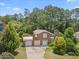 Aerial view of brick home featuring a two-car garage, a well-manicured lawn, and mature trees at 6608 Quiet Cove Ct, Raleigh, NC 27612