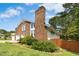 Side view of brick home, showcasing its manicured lawn and fenced yard with mature tree coverage at 6608 Quiet Cove Ct, Raleigh, NC 27612